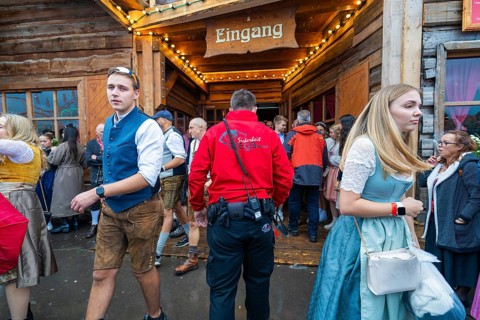 Visitors in traditional traditional costume leaving a wooden entrance at the Oktoberfest while