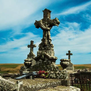 Crosses stand tall against a colorful sunset sky, showcasing the beauty of an ancient cemetery.