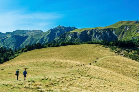 Auvergne Volcanoes Regional Park. Groups of hikers traverse a rugged path in the beautiful Sancy