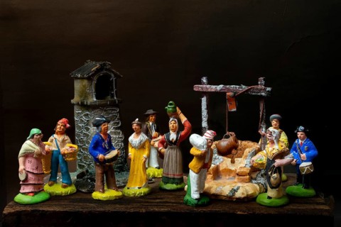 Colorful Provençal terracotta Santons figurines showcase characters engaged in various activities,