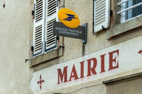 A postal agency sign is seen at the town hall in Auvergne Rhone Alpes, France. This setting