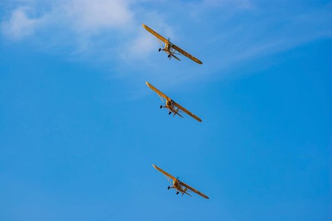 Three Piper PA-18 Super Cub aeroplanes of the Bravo Lima Formation flying in formation during an