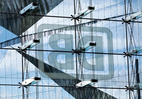 Cube Berlin seen through the glass facade of the main railway station with the mirror-inverted DB