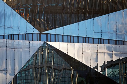 Cube Berlin, cube-shaped office building with folded glass façade reflecting the surroundings,