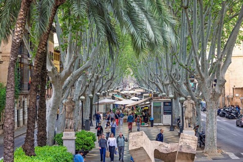Tourists walking on La rambla a tree lined walking street with flower shops in Palma, Palma de