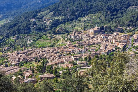 High angle view at a mountain village on a slope with lush green foliage a sunny summer day,