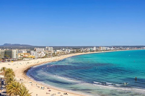 Aerial view at a tourist resort with hotels and tourists on a sand beach at a Mediterranean sea