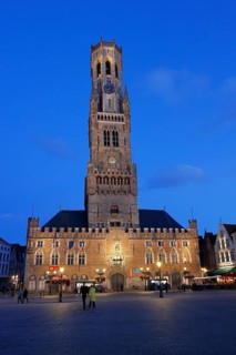 Illuminated Belfry in the historic city centre of Bruges in the evening light, Belfort and City