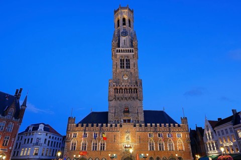 Illuminated Belfry in the historic city centre of Bruges in the evening light, Belfort and City