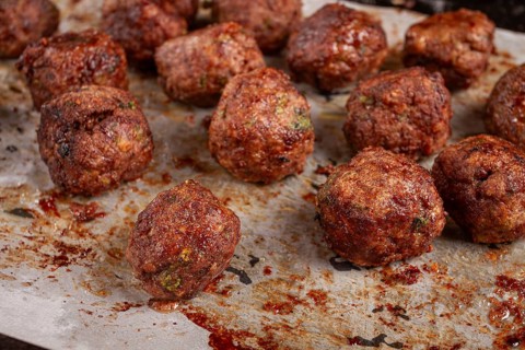 Homemade meatballs cooked to perfection on a baking tray with seasoning and herbs, Swedish