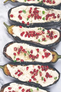 Fried eggplant with sauce, decorated with microgreens and pomegranate seeds, eggplant appetizer,
