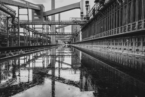 Zollverein coking plant, coke oven batteries, belt bridges and chimneys are reflected, water basin,