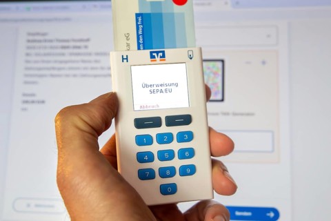 Online banking symbol image: Scanner for online banking in front of a bank website opened on a PC