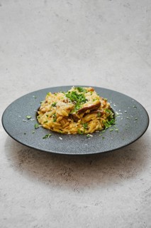 A beautifully plated dish featuring risoni pasta mixed with rich porcini mushrooms