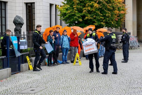 Police officers confiscate boxes from the symbolic house search of the New Generation under the