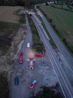 Aerial view of an operation site on a road and railway tracks, rural landscape, fire drill in the