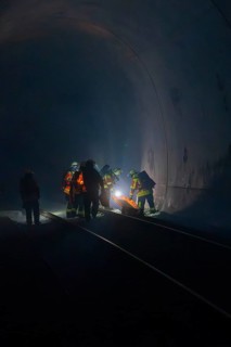 Group of firefighters in the tunnel, illuminated by a light source, fire drill in the new tunnel of