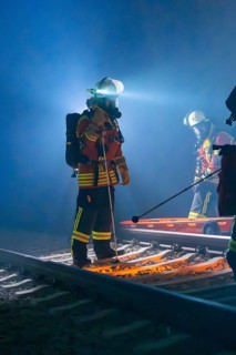 Rescue workers at work on tracks with stretcher and helmet in the dark, fire brigade exercise in