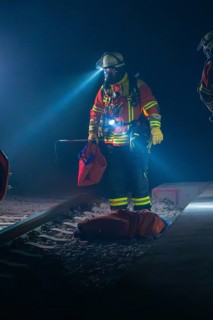 Fireman illuminates the tracks with a torch, nocturnal atmosphere, fire drill in the new tunnel of