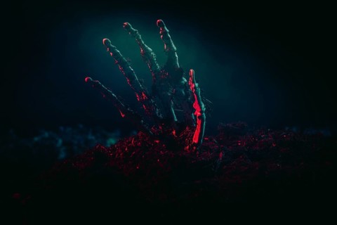 A skeleton hand shining menacingly from the earth in the light, Halloween