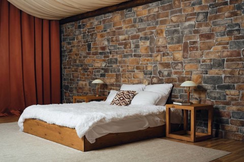 Cozy bedroom with stone wall and rustic furnishings for a relaxing atmosphere. Simple wooden
