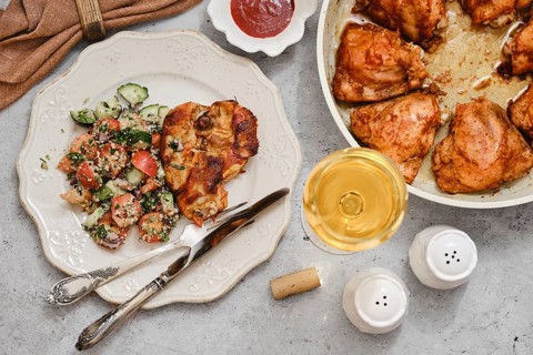 Juicy grilled chicken on a plate beside a vibrant salad made of cucumbers and tomatoes, enhanced