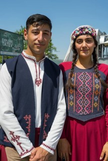 Close-up of a couple in traditional traditional costume in front of a sign, folklore, Tatev, Tatev,