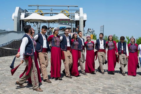 Group performing traditional dance on paved area in sunny weather, folklore, Tatev, Tatev, Syunik