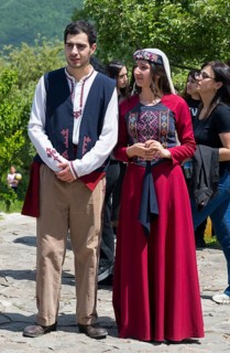 Two people in traditional clothes standing on a square in sunny weather, folklore, Tatev, Tatev,