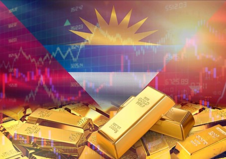 Gold bars on Antigua and Barbuda flag in background. Gold bars stacked on Antiguan flag. Concept of