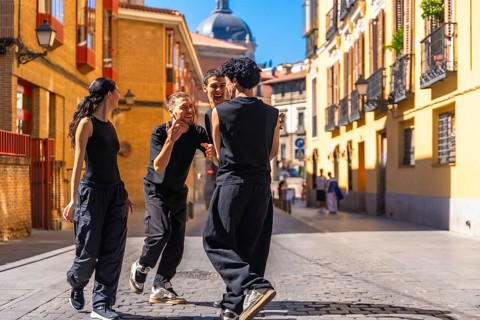 Group of diverse youth smiling, expressing joy and freedom while performing a contemporary dance