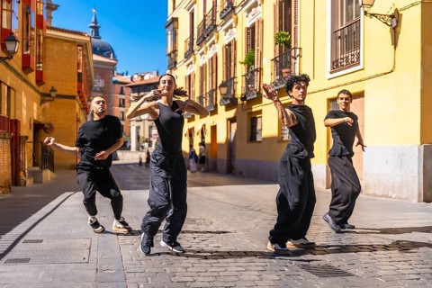 Four young dancers expressing themselves through contemporary dance, performing a street
