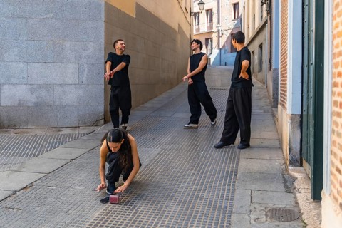 Group of young friends wearing black clothing rehearsing a contemporary dance routine on a