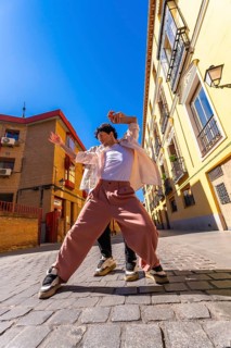 Young man actively dancing a contemporary urban street performance, expressing freedom and vibrant