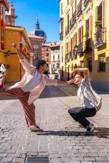 Two young men expressing emotion and movement through a modern dance routine on a cobblestone