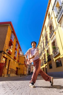 Young man expressing movement and freedom through contemporary dance in an old european city