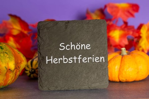 Slate plate with the inscription SCHÖNE HERBSTFERIEN and autumnal decoration