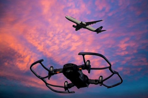 (Photomontage) Close-up of a drone in the evening sky, a Lufthansa aircraft in the background