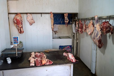 A butcher's room with pieces of meat on hooks and a table with scales, Martuni, Gegharkunik