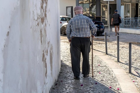 Elderly man with walking stick, in the historic centre of Lagos, Algarve, Portugal