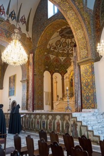 Monks pray in the magnificently decorated church with altar and chandelier, Inside the historic,