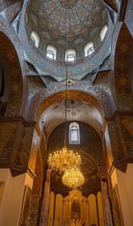 Elaborately decorated church dome with a large chandelier and artistic details, Inside the