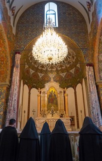 Monks gather in the richly decorated church to pray in front of the altar, Inside the historic,