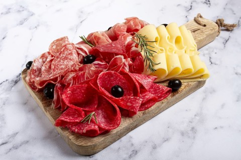 Assorted meat, appetizer, prosciutto, salami and ham, with maasdam cheese and olives, on a wooden