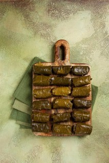 Dolma, minced meat with rice, in grape leaves, minced meat rolls, on a chopping board, top view, no