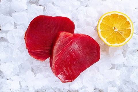Fresh tuna and lemon, on ice ready, for preparation, at a seafood market