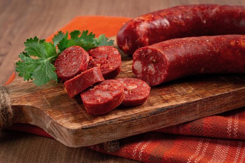 Spicy Chorizo sausage, on a cutting board, on a wooden table