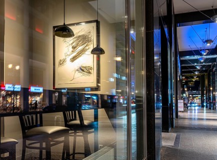Urban scene in the evening with reflections of Friedrichstraße in the window pane of a bistro,