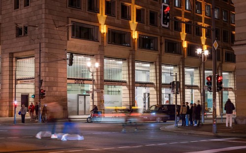 Night photo with long exposure and motion blur, pedestrians and vehicle traffic on the boulevard