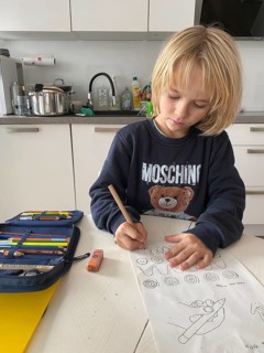 Boy, 6 years old, blond, 1st grade, practises holding the pen correctly, does homework in the